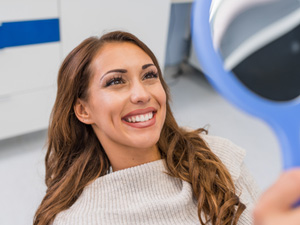 Woman smiling while looking at reflection in mirror