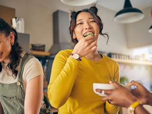 Friends enjoying snack together in kitchen