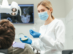 Dentist showing patient clear aligner in treatment room