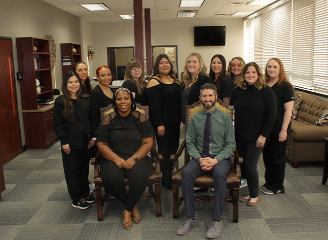 Oklahoma City orthodontist and team smiling in reception area of Casady Square Orthodontics