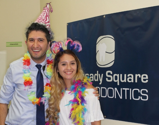 Doctor Ishani with orthodontic patient wearing leis and party hats