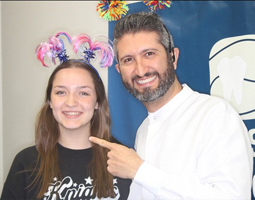 Doctor Ishani with young woman pointing to her smile after getting braces off