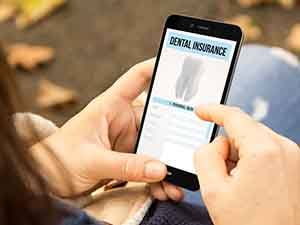 Patient in Oklahoma City checking their dental insurance for orthodontic emergencies