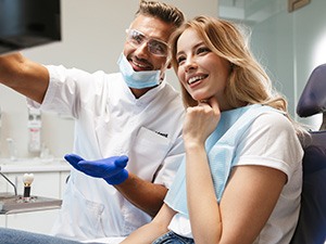 Dentist and patient smiling while reviewing image