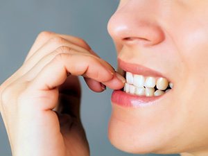 Closeup of woman biting her nails